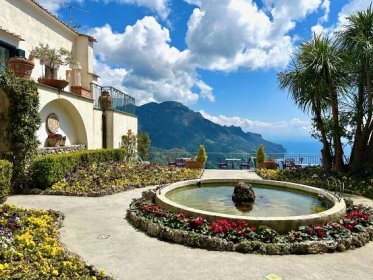 Garden in bloom with a koi pond and view to the sea and mountains at Parsifal hotel in Ravello on the Amalfi Coast