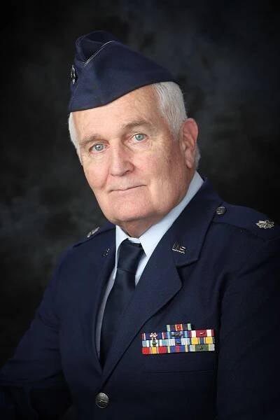 Military portrait of a service member in dress blues with medals and decorations.