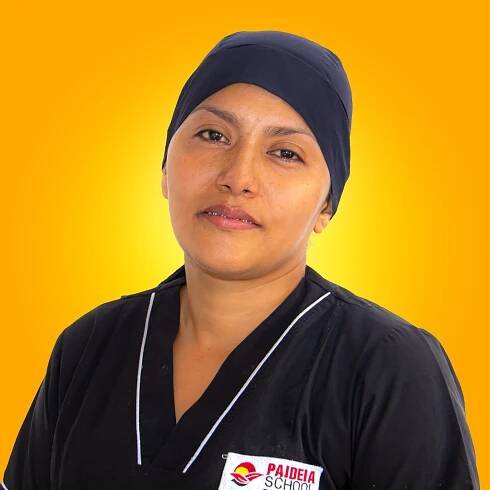 Una mujer vestida con uniforme de chef de la escuela Paideia.