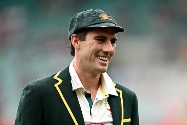 Australia men's Test cricket captain Pat Cummins wearing a hat and jacket, walking on the field