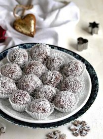 Nepečené kokosové kuličky, vánoční cukroví servírované na talíři. 