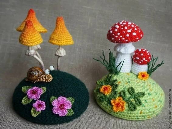 two small crocheted mushrooms sitting next to each other on top of a table