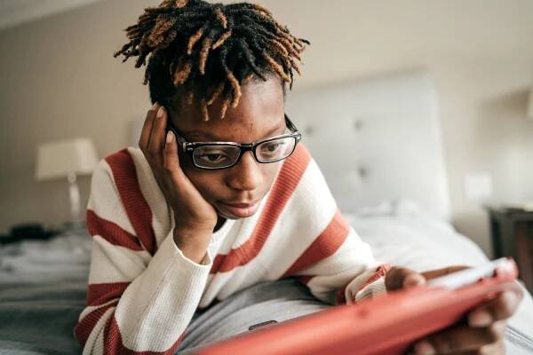 Introverted child completes homework on her iPad