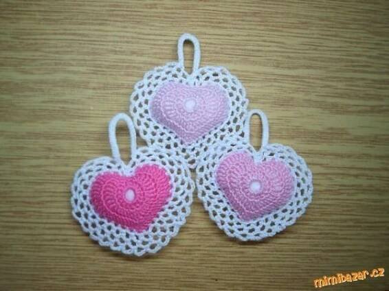 three crocheted hearts are sitting on a table