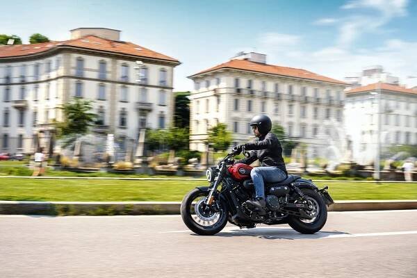 A rider on a Keeway V302 C is cruising through a city street
