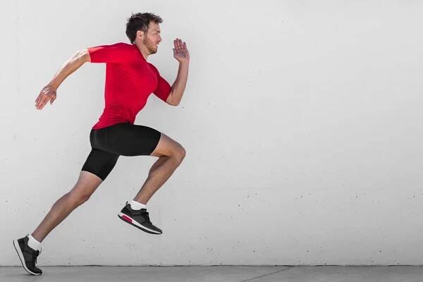 Běžící man runner trénink dělat venkovní město běh sprintovat podél zdi pozadí. Městský zdravý aktivní životní styl. Muž atlet dělá sprint hiit vysoký interval intenzity trénink. — Stock obrázek