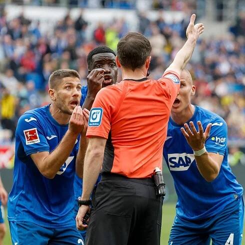 Hoffenheims Spieler diskutieren mit Schiedsrichter Benjamin Brand beim Spiel gegen Dortmund.