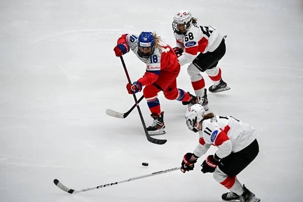 Michaela Pejzlová v obležení protihráček rozjíždí akci... | České hokejistky zahájily světový šampionát vítězstvím proti