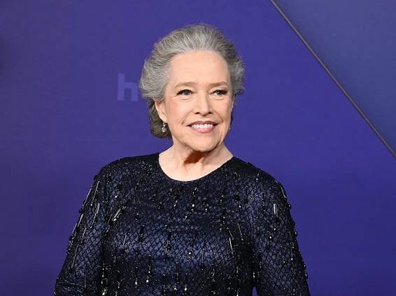 Kathy Bates dressed in a glittery black dress at a red carpet event.