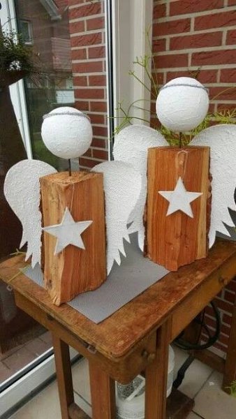 three wooden blocks with white stars and wings on them, sitting on a table in front of a window