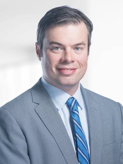 A man in a suit and tie is smiling for the camera.