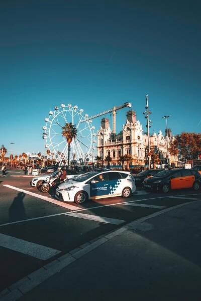 bezplatná Denní pouliční scéna v Barceloně s ruským kolem, historickou architekturou a dopravou. Základová fotografie
