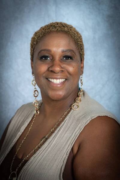 African American women with a smile and tan vest