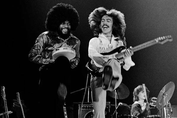 LANDOVER, MARYLAND - DECEMBER 13: (NO U.S. TABLOID SALES) Singer/songwriter and former Beatles member, George Harrison (R) and band memeber, keyboardist Billy Preston perform on stage during their "North American Tour" at the Capitol Center December 13, 1974 in Landover, Maryland. (Photo by David Hume Kennerly/Getty Images)