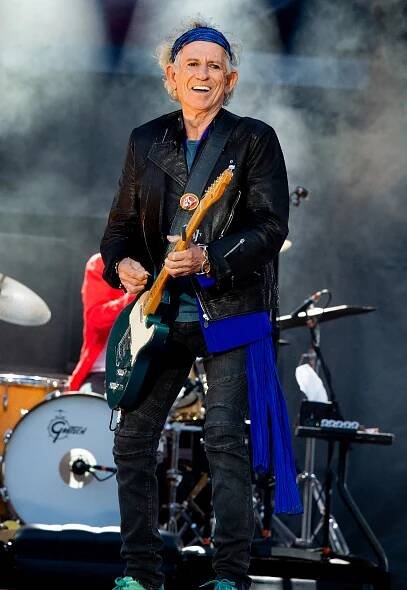 Keith Richards of the Rolling Stones performing on stage with a guitar.