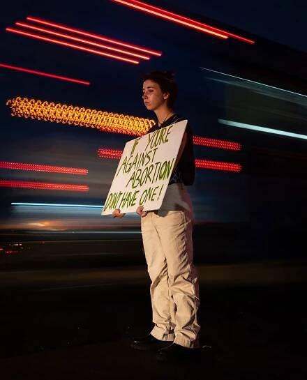 Sept. 27, 2022; Austin, TX, USA; Cullen Savory, 19, holds a sign up to passing traffic at an International Safe Abortion Day