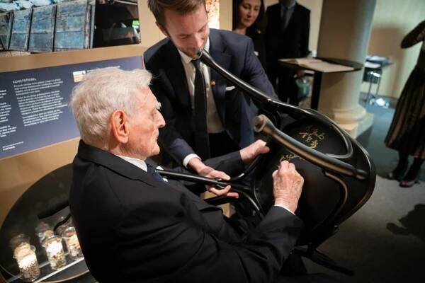 John B. Goodenough autographs a chair