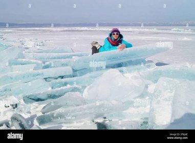 A woman of 35-40 years old lies on an ice hummock on the ice Stock Photo