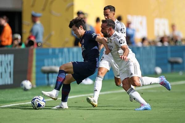 Paris Saint-Germain's Lee Kang-in challenged by Real Madrid's Lucas Vazquez and Dani Carvajal during a FIFA Club World Cup semi-final match.