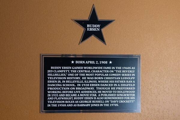 A plaque of a star reading "Buddy Ebsen". Below the information continues on a rectangular plaque: "Born April 2, 1908 Buddy Ebsen gained worldwide fame in the 1960s as Jed Clampett, the central character on "The Beverly Hillbillies," one of the most popular comedy series in television history. He was born Christian Ludolpf Ebsen Jr. In Bellevile, Illinois, where his father ran a dancing school. In 1928, Ebsen danced in a Ziegfeld Production on Broadway. Though he preferred owrking before live audiences, he moved to Hollywood in 1935 and became a movie star. A published songwriter and playwright, Buddy Ebsen is also remembered for his television roles as Georgie Russel on "Davy Crockett" in the 1950s and as Barnaby Jones in the 1970s.