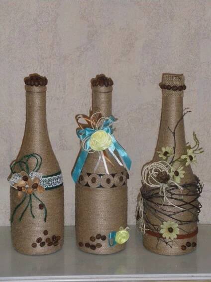 three wine bottles decorated with ribbons and flowers