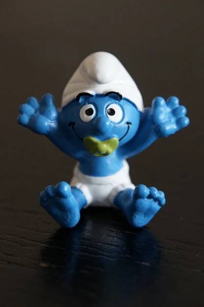 Baby Smurf wearing a diaper and a light green pacifier