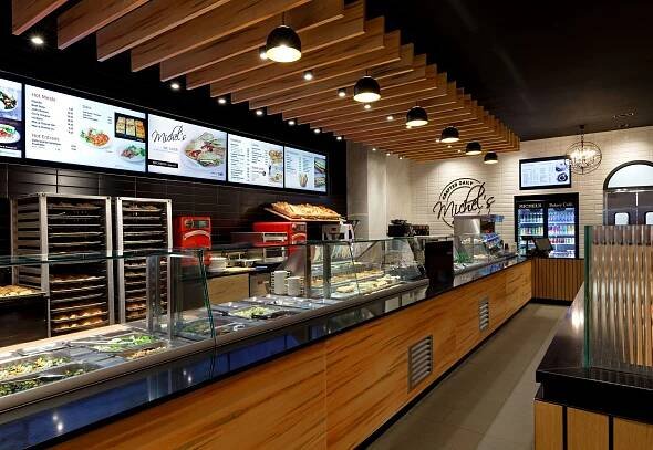 A very long counter in a restaurant with a lot of food on it