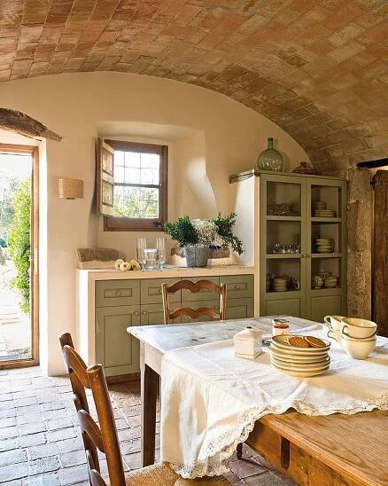 a table with plates and bowls on it in a room that has an arched ceiling