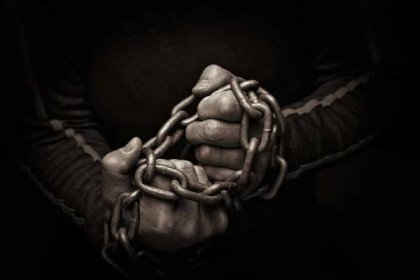 Close-up of hands trying to break chains