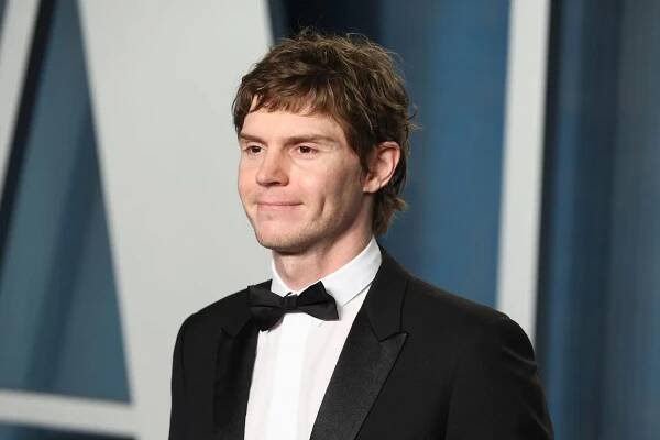 A person in a tuxedo smiles while posing for a photo at a formal event.