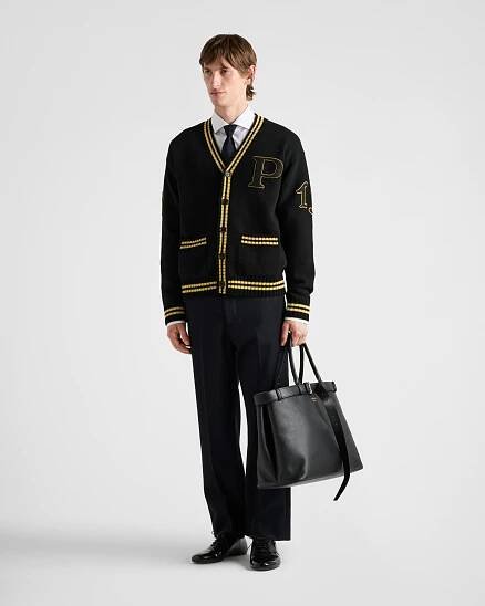 Prada's 1913 menswear capsule, including white varsity jacket, black bomber and knit cardigan