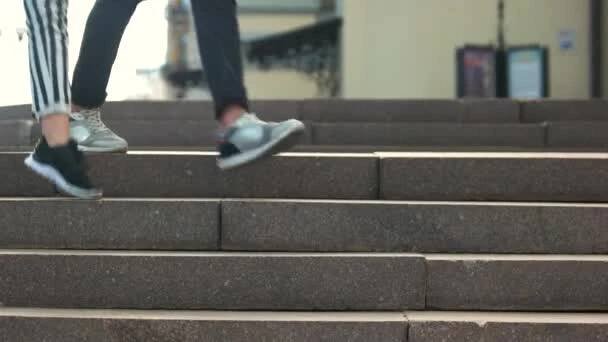 Zavřít nohy mladého páru při chůzi po schodech. — Stock záběr