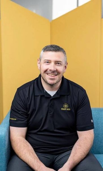 orange bee employee in black polo