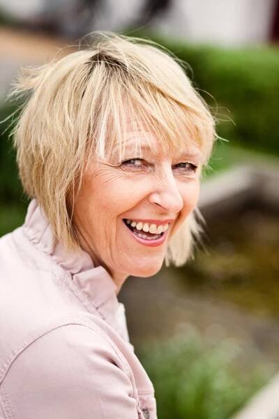 Close-up of smiling mature woman against rocks – Astrakan Images