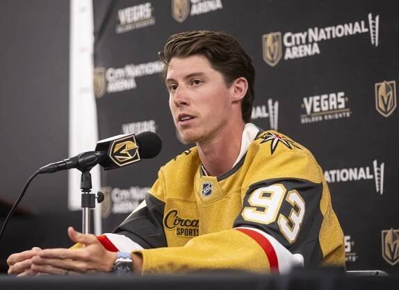 Mitch Marner in a Vegas Golden Knights jersey at a press conference.