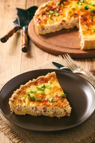 a slice of quiche on a black plate