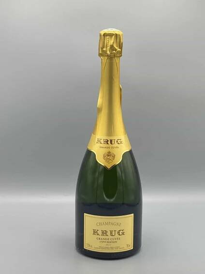 Bouteille de Champagne Krug Grande Cuvée 172ème Édition Brut, dans son coffret élégant, posée sur une table raffinée