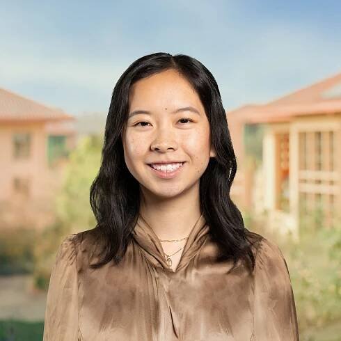 A headshot of a woman with a college campus in the background.