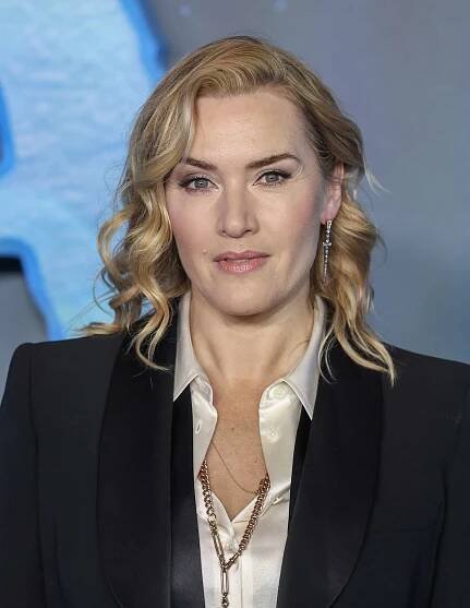 Kate Winslet side-parted wavy blonde hair, defined brows, and romantic makeup