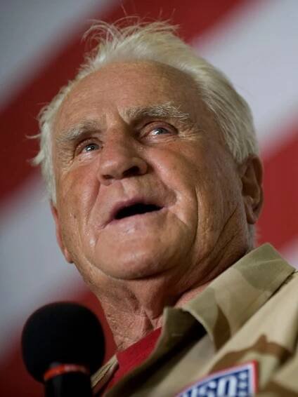 National Football League (NFL) hall of fame coach Don Shula addresses the crew of aircraft carrier USS Ronald Reagan (CVN 76), under way in the Gulf of Oman, July 13, 2009, during a United Service Organizations tour to the U.S. Central Command area of operations. The tour also features all-pro NFL running back Warrick Dunn, actors Bradley Cooper and D.B. Sweeney and sports announcer and model Leeann Sweeden. (DoD photo by Mass Communication Specialist 1st Class Chad J. McNeeley, U.S. Navy/Released)