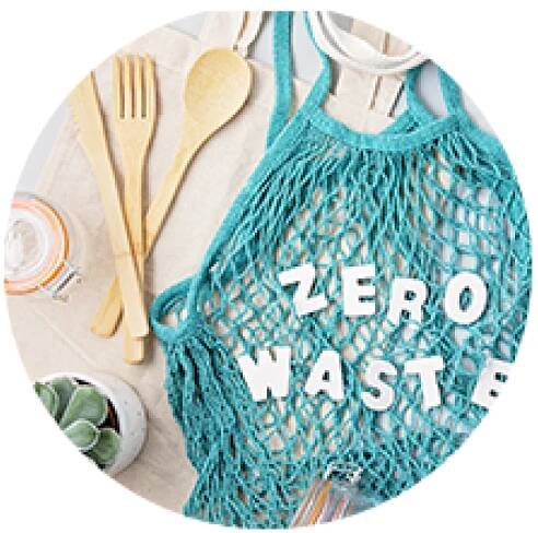 A resuable bag that says Zero Waste with other sustainable items surrounding