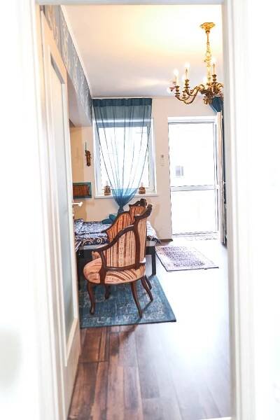 a living room with a chair and a bedroom at Apartmán MIKU-LOVE in Mikulov
