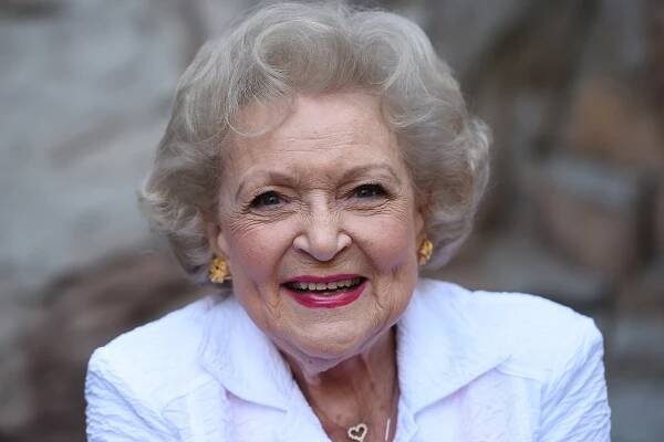 Betty White smiling in a white blazer.