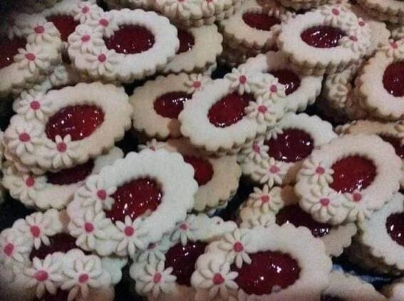 there are many cookies that have been decorated with icing and strawberry jam on them