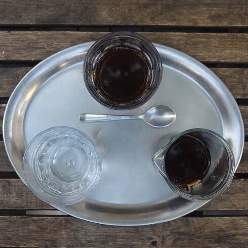 My pour-over, a natural Nicaraguan single-origin, presented in a carafe on an oval tray, along with a glass of water at Mamacoffee Londýnská in Prague.