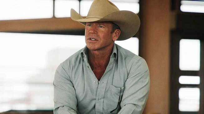 Taylor Sheridan as Travis Wheatley looks across frame as he sits on a horse in Yellowstone
