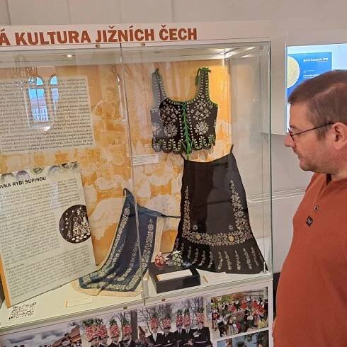 Etnograf Jan Šimánek před vitrínou s výšivkami z rybích šupin v Jihočeském muzeu | foto: Zdeněk Zajíček,  Český rozhlas
