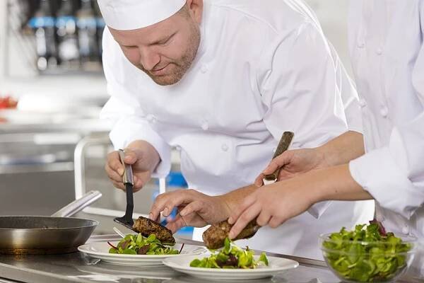 Profesionální kuchař připraví jídlo steak v restauraci — Stock obrázek