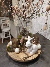 a table topped with a vase filled with flowers and an easter bunny figurine