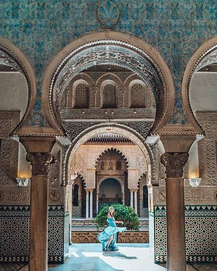 girl standing amongst the moorish architecture of royal alcazar of seville spain